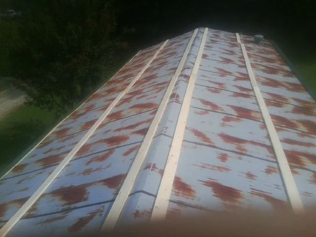 Rusted metal roof panels with new wood purlins before replacement — Storm Damage Roof Repair in Hastings by Roofing Brothers
